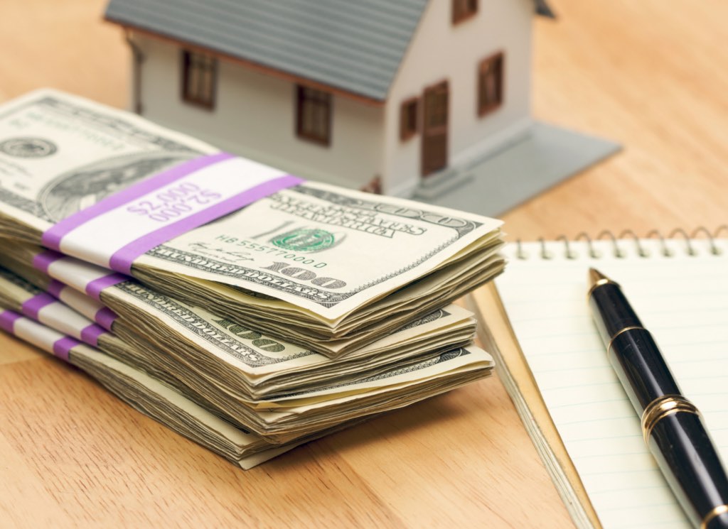 A house key and a small stack of coins representing down payment assistance eligibility for Minnesota buyers.