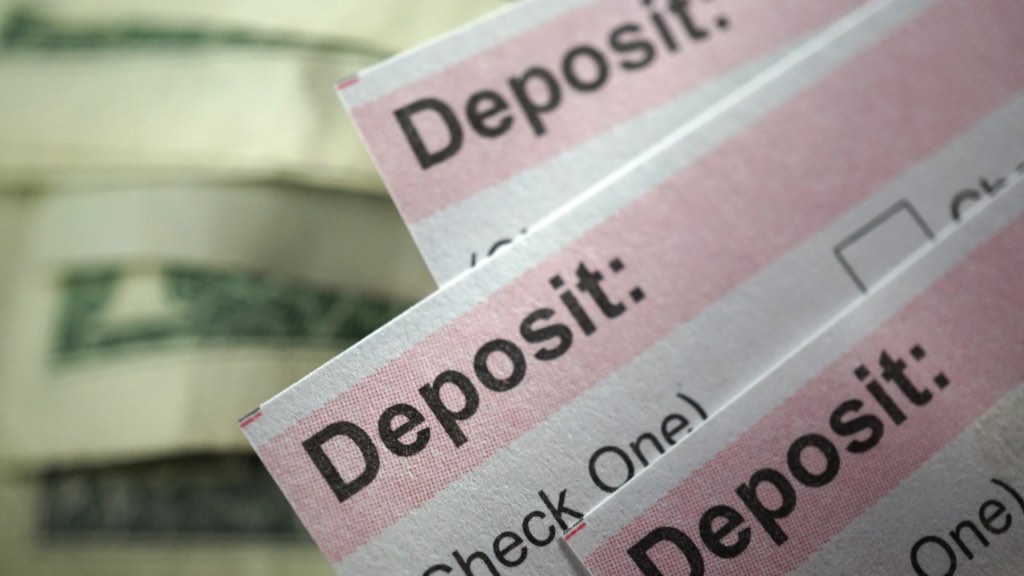 Immigrant homebuyer reviewing international bank transfer documents while preparing to purchase a home in Minnesota