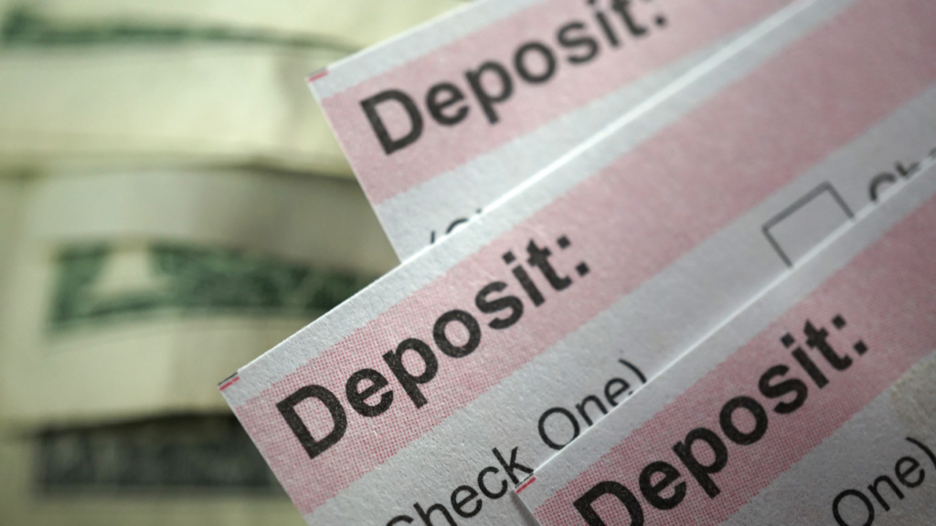 Immigrant homebuyer reviewing international bank transfer documents while preparing to purchase a home in Minnesota