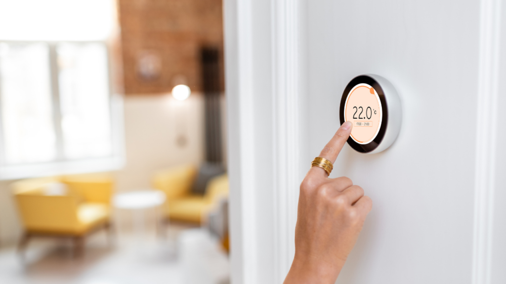 Minnesota homeowner adjusting thermostat while snow falls outside during winter