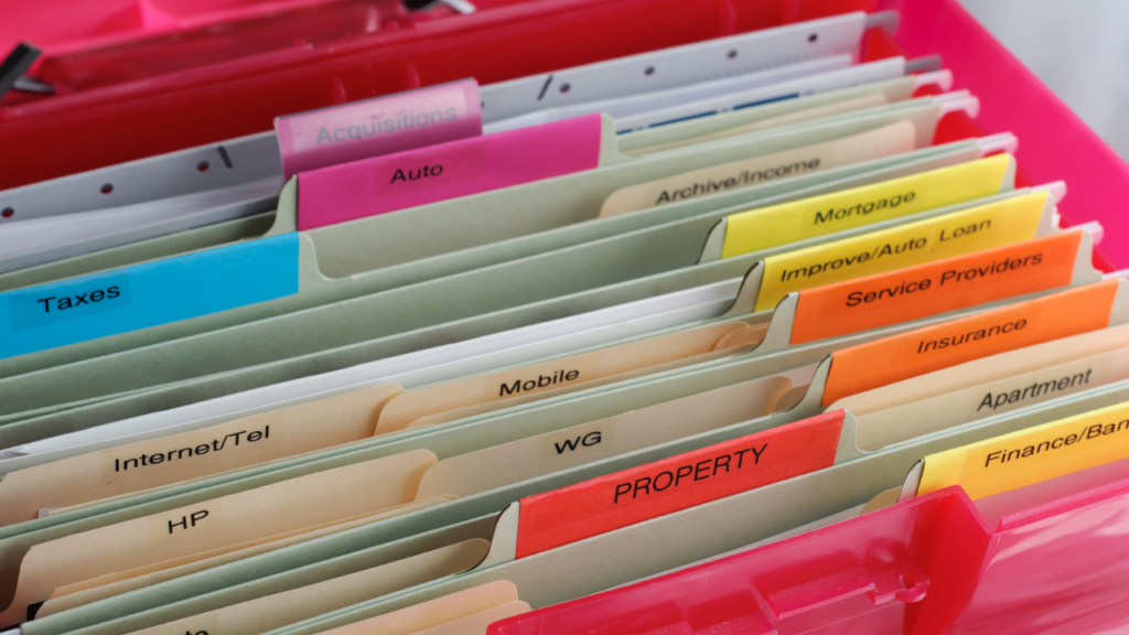 Minnesota home seller organizing closing documents in a home file after completing their real estate transaction in the Twin Cities